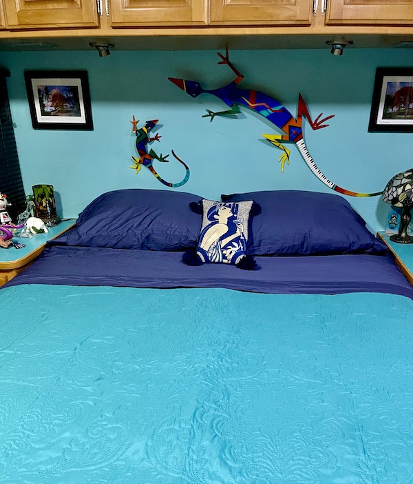 Bedroom with navy sheets and turquoise quilt