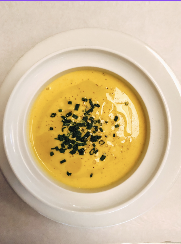 Tasting Arizona Chilled Mango Soup in a white bowl garnished with chives