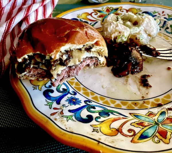 Half eaten burger with mushrooms and cheese that was grilled on our new Weber Jumbo Joe Charcoal Grill