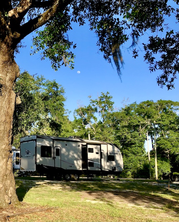Large travel trailer in the woods is an example of What Type of RV is Best for You?