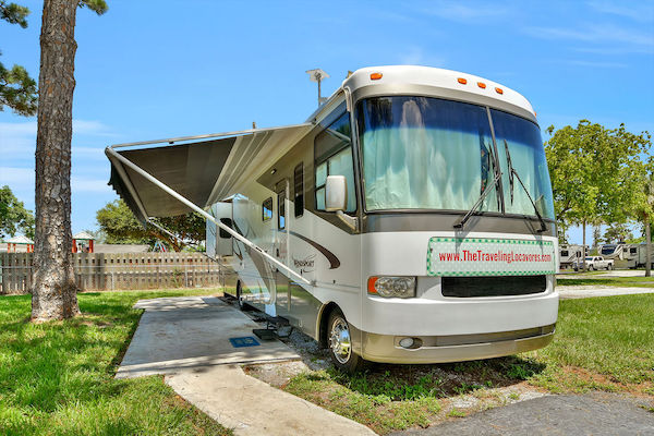 Class A motorcoach with awning out at an RV park.