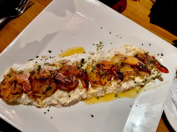 From Bimini Twist Restaurant WPB FL large white plate topped with risotto and shrimp.