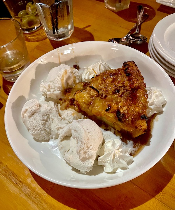 Large white bowl with a wedge of Apple Pie, pecan sauce and several scoops of vanilla ice cream at Bimini Twist