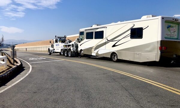 A large motorcoach being towed by a huge tow truck, part of RV Checklist for First Trip