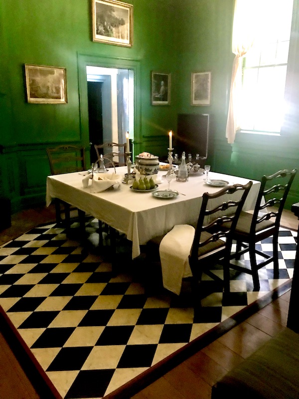 Beautiful dining room at Mt. Vernon with emerald green walls and black and white floor.