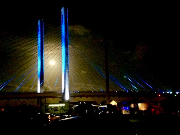 Suspension bridge with blue lights and a full moon