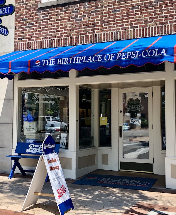 Blue awning over store front that is the birthplace of Pespsi