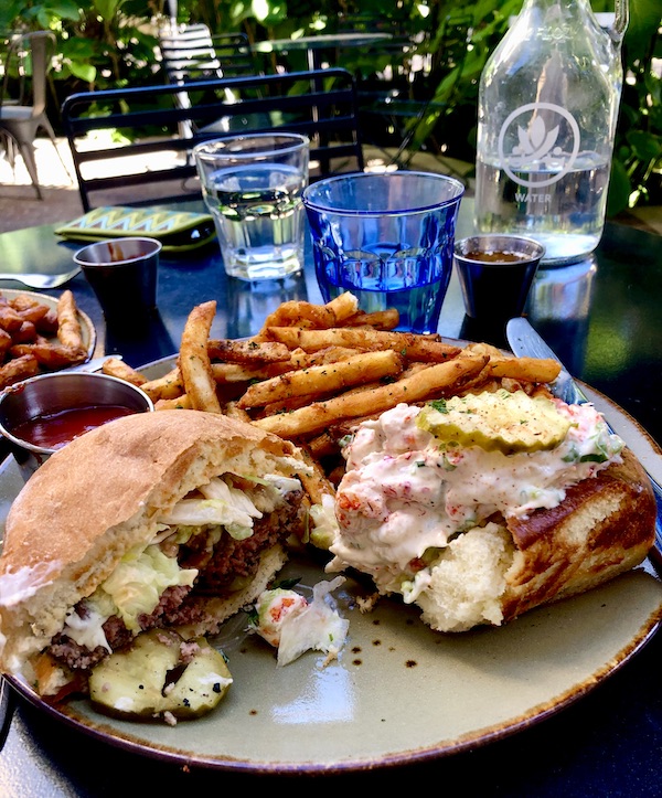 Lunch plate topped with half a burger and half of a lobster roll at a restaurant in San Antonio