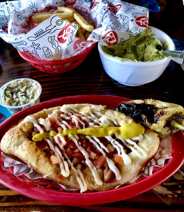 Red plate topped with a hotdog in a bun with lots of condiments in Tucson AZ. Part of my 3 Years RVing Year 1 Recap