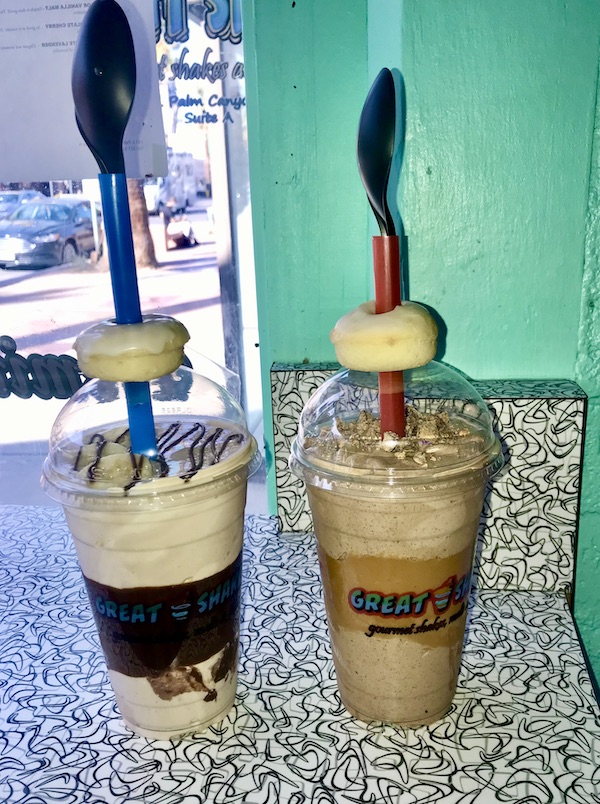 A pair of milkshakes with straws, spoons and mini donuts from Great Shakes in Palm Springs CA.
