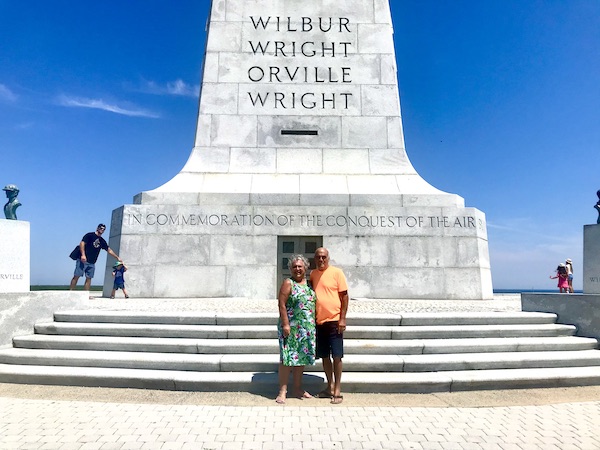 Huge white stone monument to the Wright Bros. with Steve and I standing in front.