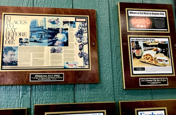 Framed newspaper articles about a Kansas City BBQ restaurant hanging on a green wall. Part of my 3 Years RVing Year 1 Recap