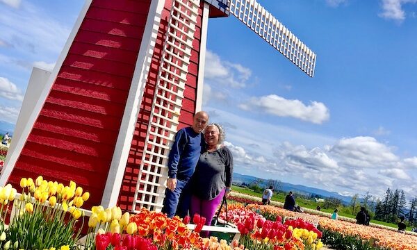 Red and white windmill, us and lots of colorful tulips, part of my 3 Years RVing Year 2 Recap.