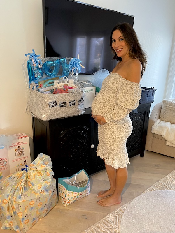 Our niece in a white dress standing by her baby shower gifts. Part of my 3 Years RVing Year 3 Recap