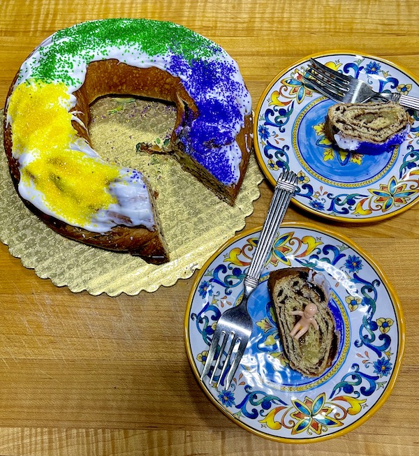 Cake ring of purple, yellow and green and two slices of cake on a wood table. Part of my 3 Years RVing Year 3 Recap