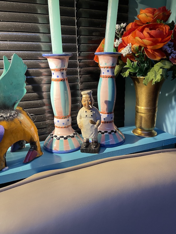Turquoise shelf behind a sofa with candlesticks and other art displayed. Part of my 3 Years RVing Year 3 Recap