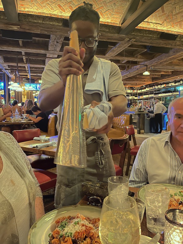 Man grating cheese onto our dishes at Elisabetta's Ristorante Bar Pizzeria