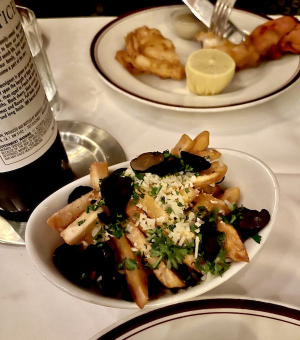 Chops Lobster Bar Boca Raton sharable side of fries with parmesan and shaved truffles in an oval white bowl.