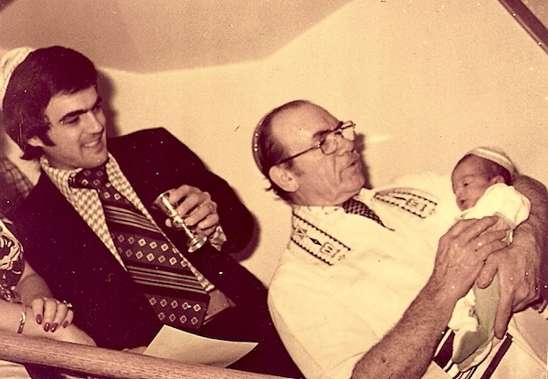 Rabbi holding our son with Steve and I behind him on stairs at Brian's bris.