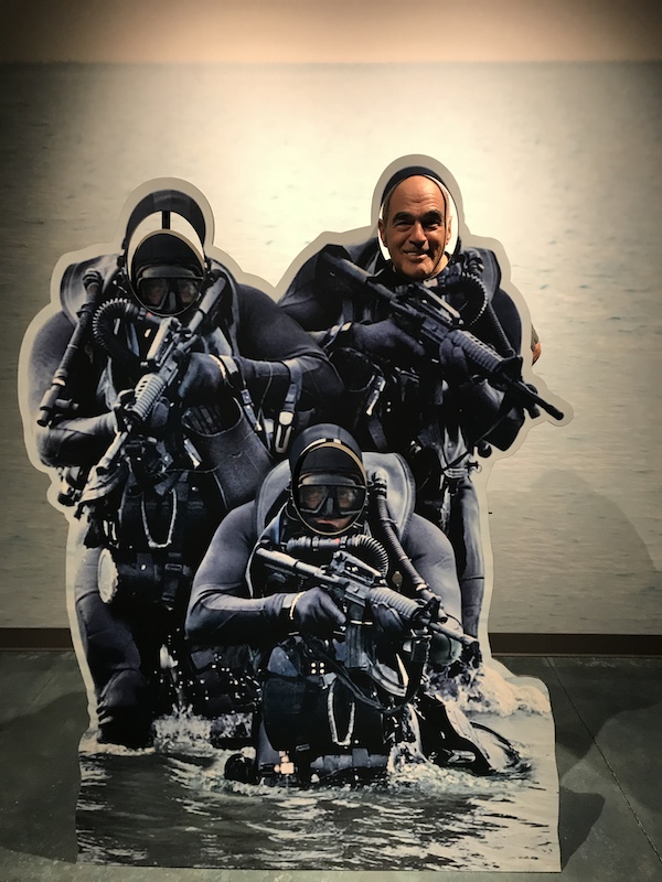 Steve with his head in photo board of one of 3 Navy SEALS.