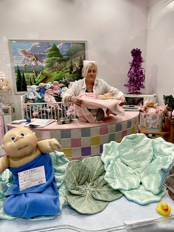 Nurse weighing a newborn Cabbage Patch baby at Babyland Cleveland GA