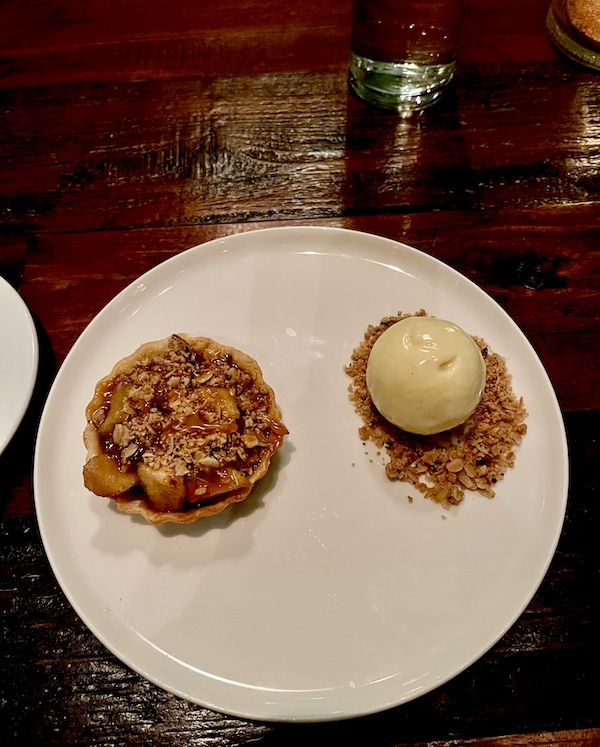 Individual apple tart on plate with streusel and a scoop of vanilla ice cream for dessert at Five and Ten Athens GA