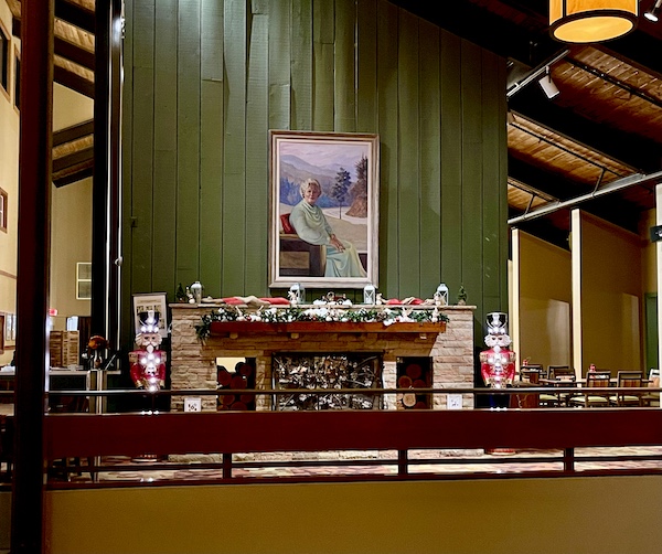Holiday Season in Helen Georgia inside a Lodge with a large fireplace, green wood wall and portrait of a woman