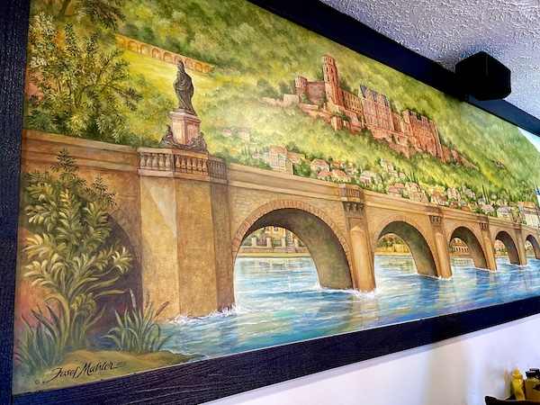 The Heidelberg Restaurant Helen GA mural of an arched bridge over water
