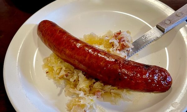 The Heidelberg Restaurant Helen GA Smoked sausage on a bed of sauerkraut with a fork on a white plate