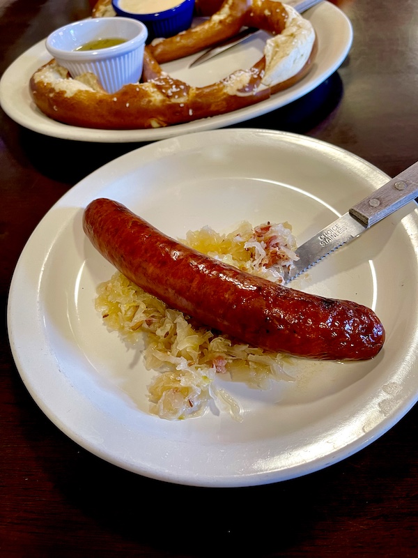 The Heidelberg Restaurant Helen GA Smoked sausage on a bed of sauerkraut with a fork on a white plate