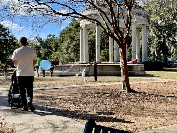 Boy creating a big bubble in front of Café du Monde City Park NOLA