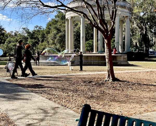 Boy creating a giant bubble in front of Café du Monde City Park NOLA