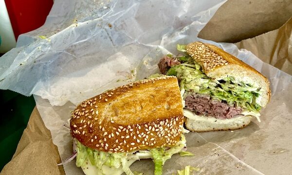 Francolini's Italian Deli NOLA seeded sub with roast beef and lettuce sitting on deli paper