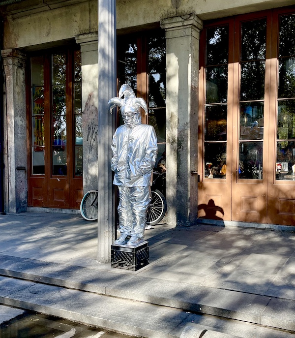 Silver jester sculpture on milk crate in Jackson Square New Orleans