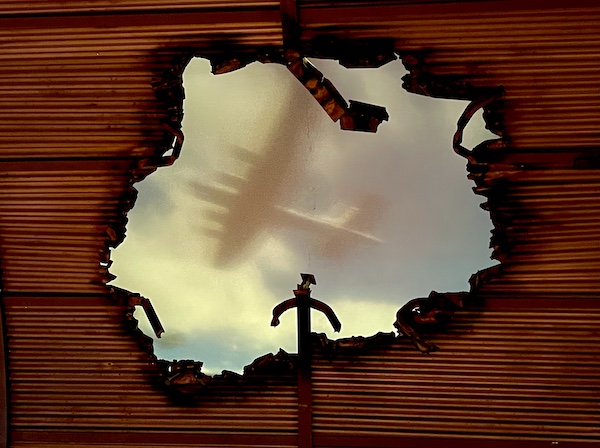 Torn roof exposed to the sky with WW2 planes seen flying overhead