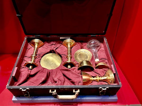 Suitcase with red lining holding items for an Army chaplain to use for religious services
