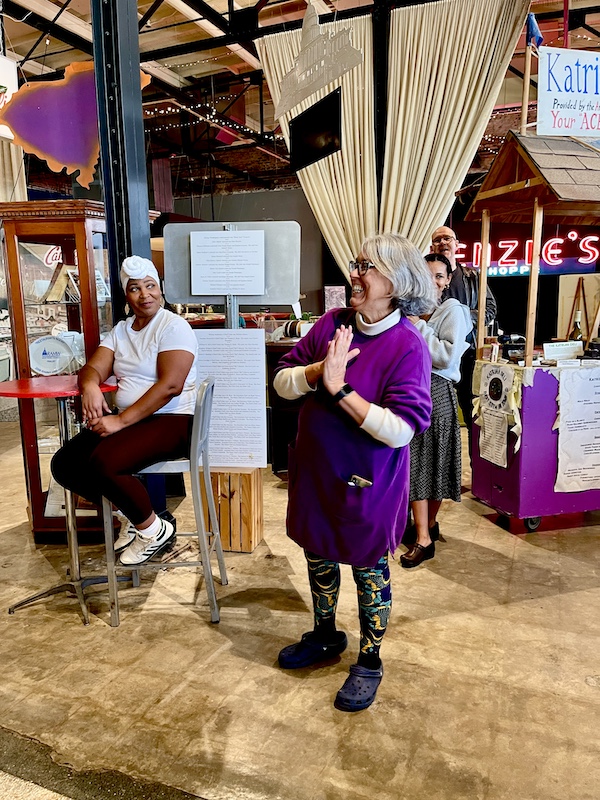 Silver haired woman in purple blouse with microphone at SoFab NOLA is So Fabulous!