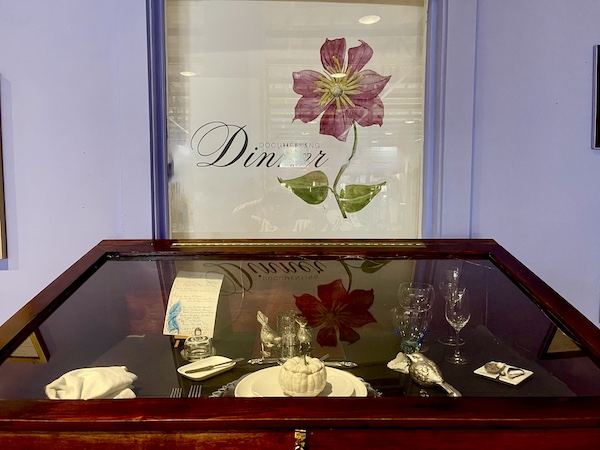 Dark wood and glass display case with setting for formal dinner at SoFab NOLA is So Fabulous!