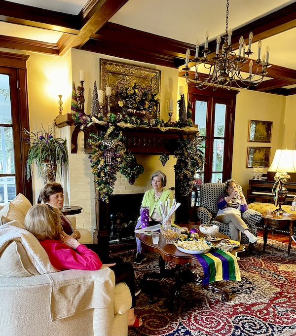 People sitting in a living room that is decorated for Mardi Gras