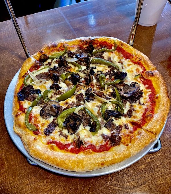 Whole pizza on pan topped with cheese, steak and veggies on our way to Global Wildlife Center Folsom LA
