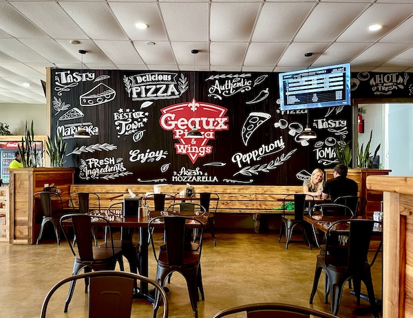 Before we went to Global Wildlife Center Folsom LA we went to Geaux Pizza. Interior has chalkboard sign behind seating.