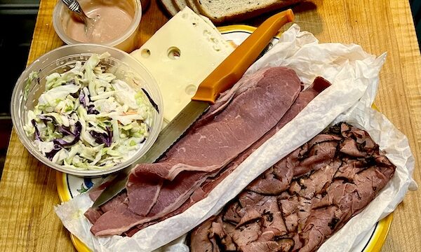 Platter topped with sliced pastrami and corned beef on deli paper, along with a dish of coleslaw, Russian dressing, mustard and rye bread slices. Mostly from Kosher Cajun NY Deli and Grocery