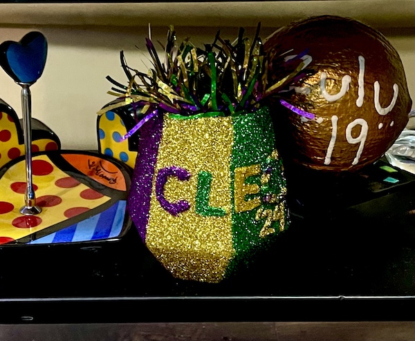 Glitter covered stemless wineglass and candy dish on a black shelf showing our Mardi Gras State of Mind
