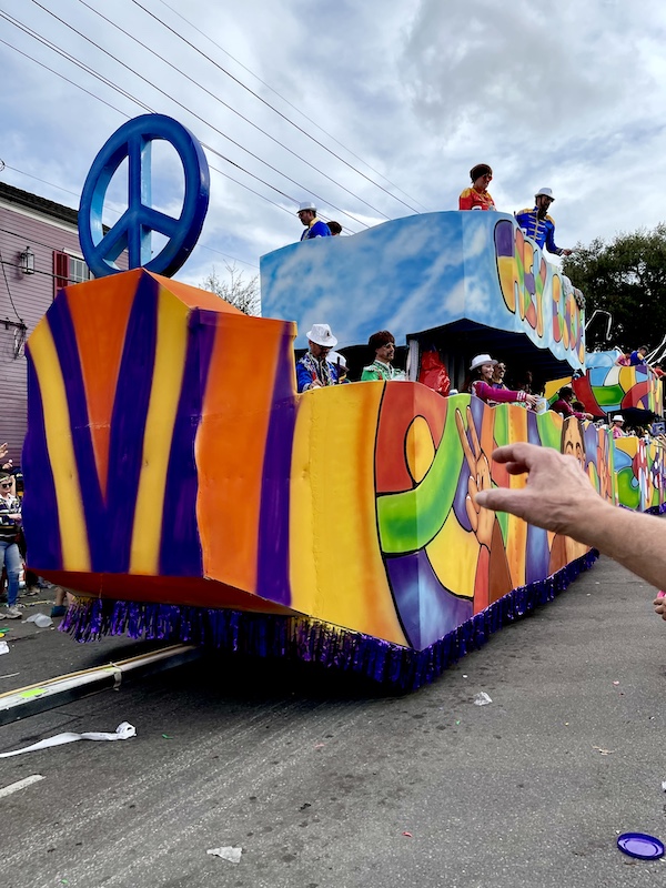 Multicolor float with peace sign at Our First Mardi Gras Parade