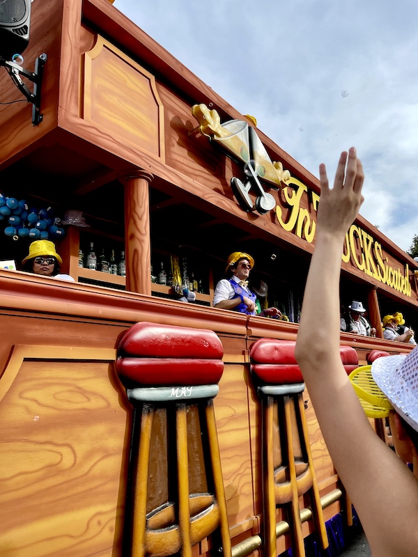 Wood float that look like a bar complete with bar stools and bartenders throwing beads at Our First Mardi Gras Parade