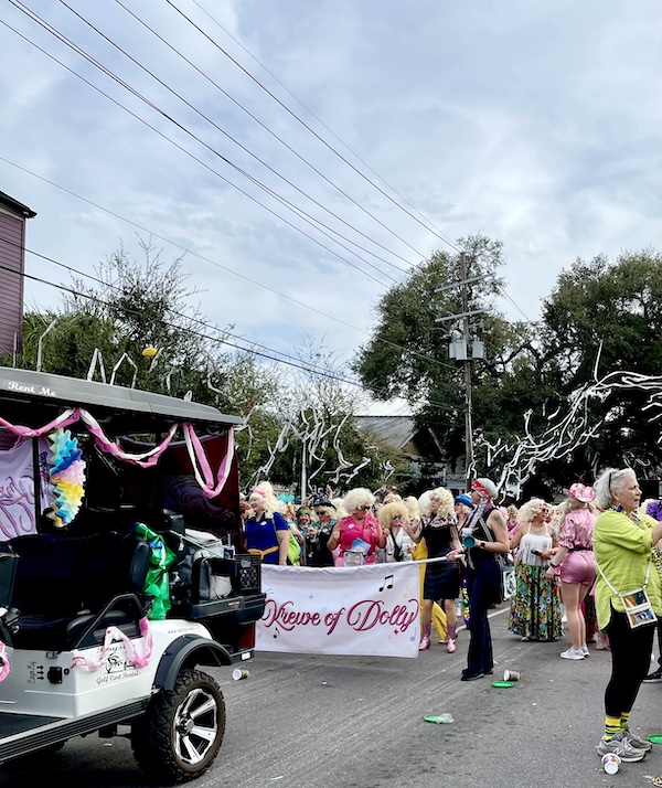 A group of women marching in Our First Mardi Gras Parade dressed up like Dolly Parton