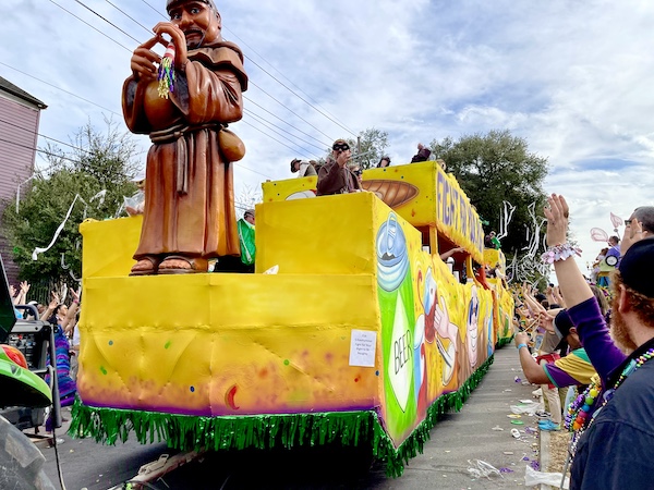 Bright yellow float with statue of Friar Tuck at front at Our First Mardi Gras Parade