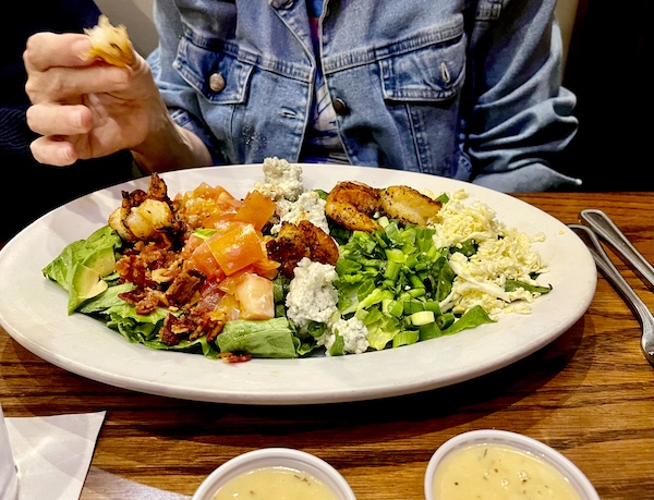 Fish City Grill Pearland TX large salad on an oval plate with shrimp, eggs and blue cheese.