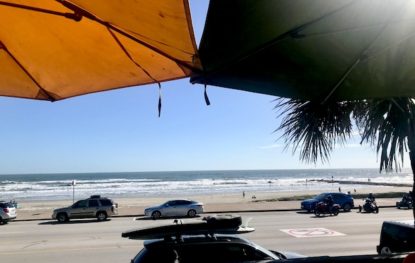 Looking at the beach and ocean framed by two market umbrellas on Galveston Island