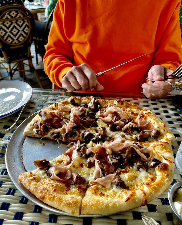 At George's Bistro and Bar Houston TX we shared the mushroom and prosciutto pizza served on the pan. Shown with my slice missing.